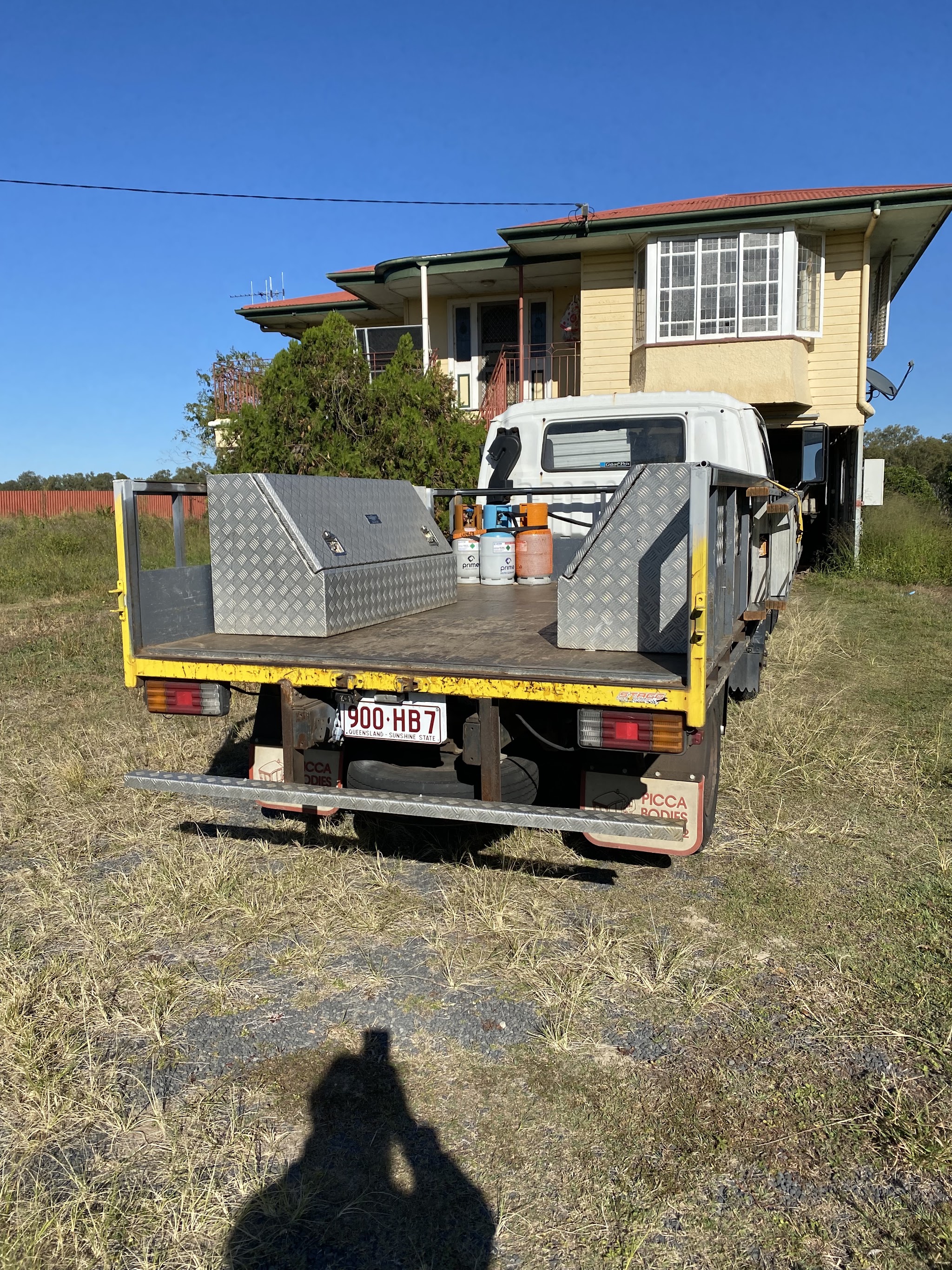 The MixAir work truck, a tray back with a checkerplate toolbox and refrigerant cylinders on the deck