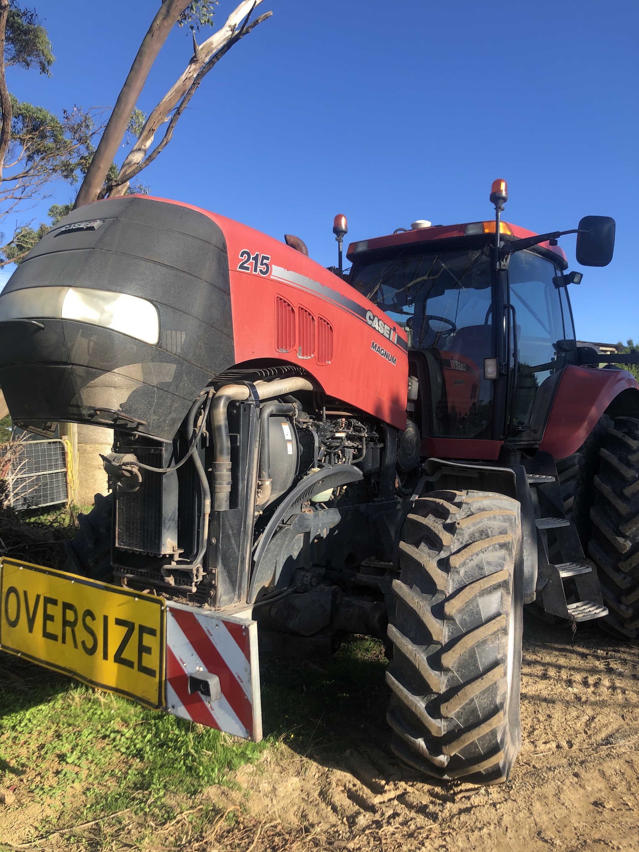 A Case IH Magnum 215 tractor with the bonnet raised and the radiator and condenser stack exposed for air conditioning work